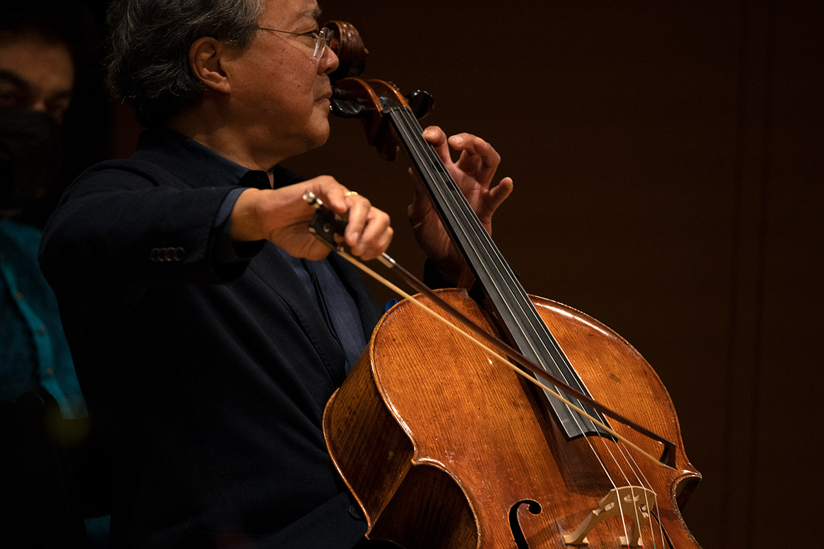 Man on stage playing cello.