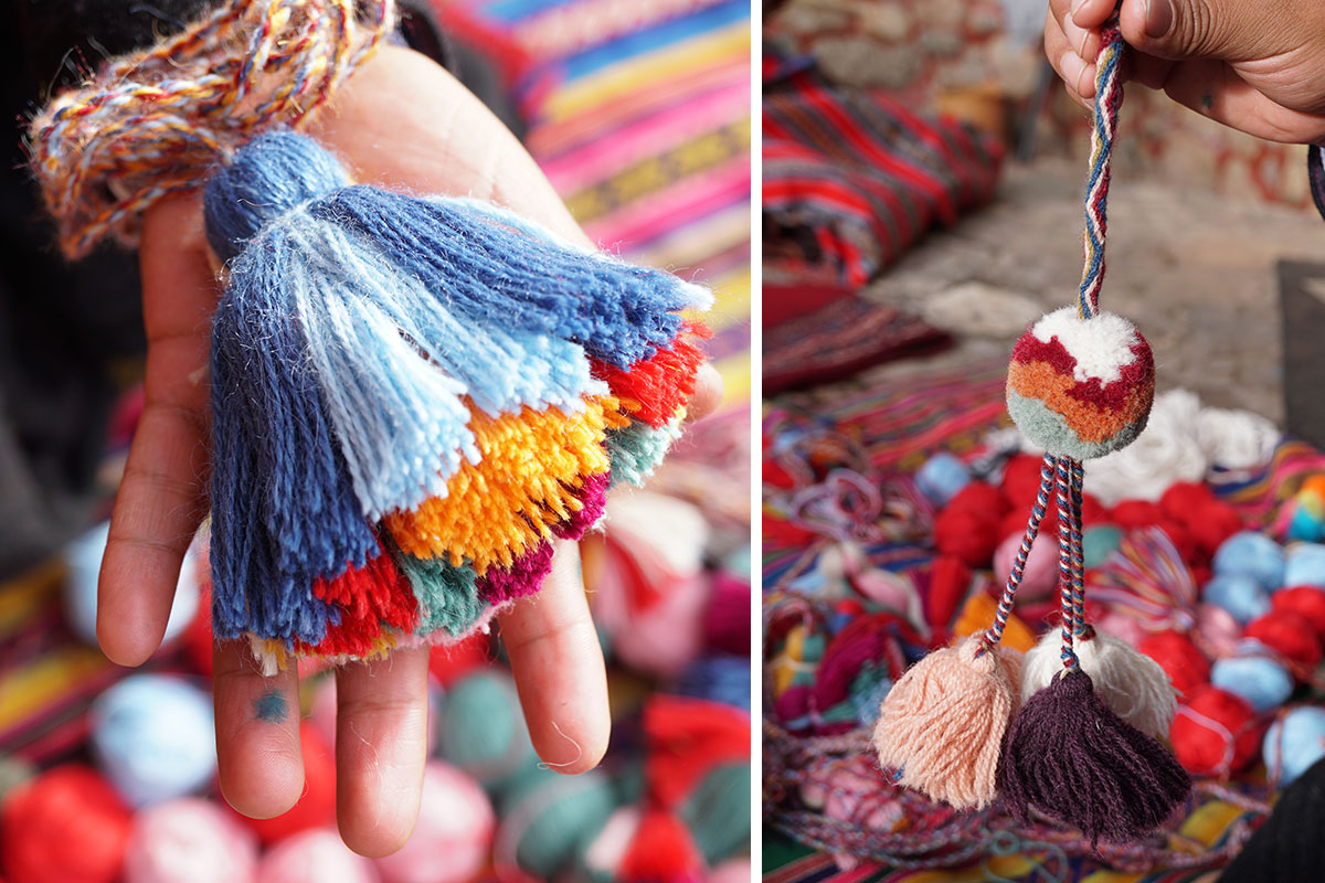 On the left, closeup of a hand holding up a multicolored yarn tassel. On the right, a hand holds up a yarn pom-pom.