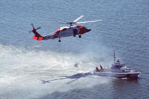Coast guardsmen aboard the Jayhawk helicopter and a 41-foot utility boat pictured at left are demonstrating their skills during Coast Guard Missions Day in Yorktown, Virginia. USCG photo by PA2 Jacquelyn Zettles, courtesy the U.S. Coast Guard