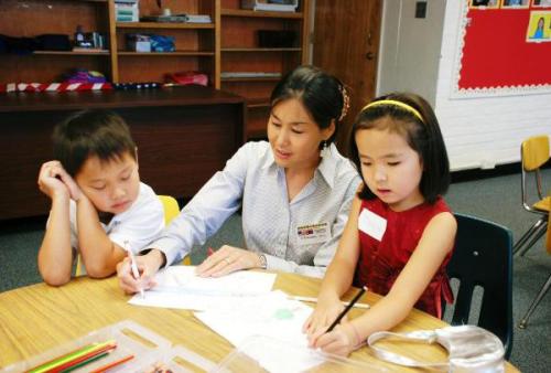 Kindergarten teacher Khandmaa Wyckoff works with two students at a Virginia-based Mongolian school.