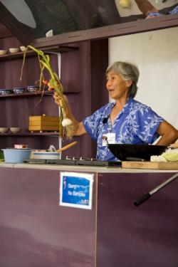Hiu Newcomb, owner of Potomac Vegetable Farms, a Fairfax county organic farm, demonstrates stir-fried chicken with fresh greens using ingredients from her farm, 2010 Smithsonian Folklife Festival.