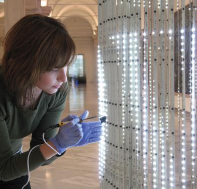 Conservation technician Susan Edwards maintains Jenny Holzer's light sculpture at the Smithsonian American Art Museum.