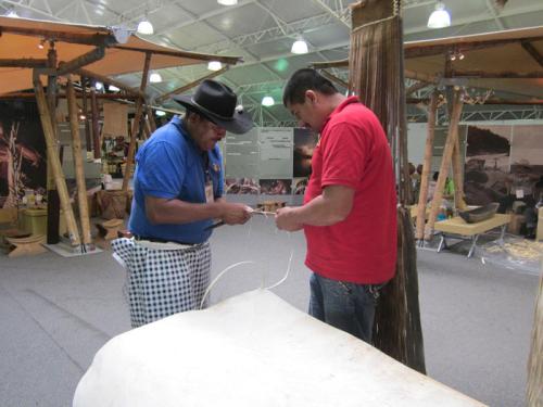 Hermes Romero from the Southeastern Plains makes a key chain for Jhon Jairo "Guama" Amortegui, a yipero (jeep driver) from the Coffee region.