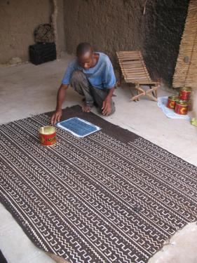 Moussa Fofana applies dye to the cloth.