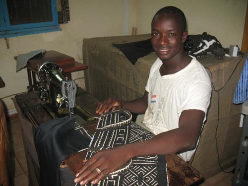 Issa T&eacute;ssougu&eacute; sews the bags.