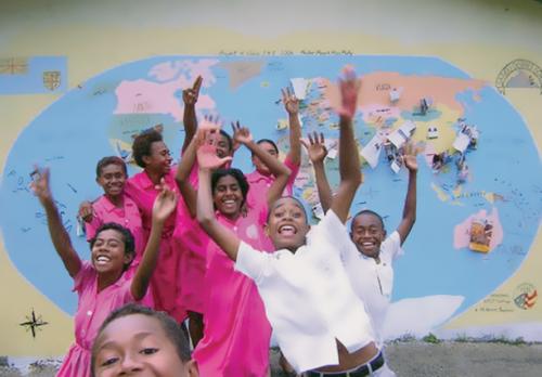 Students and the world map they drew in Fiji.
