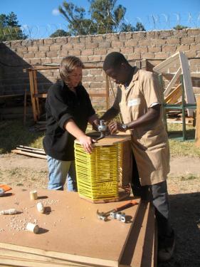 Peace Corps volunteer Kristina Denison and Bernard Kiwia assemble a pedal-powered washing machine.