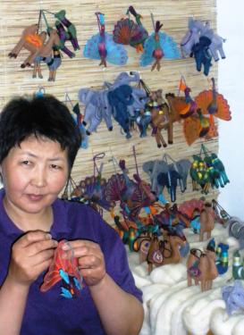 Lira Osmonakunova puts the finishing touches on a peacock ornament made from felt.