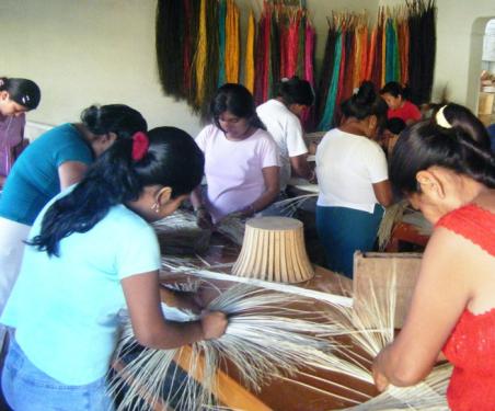 Women from the Virgen del Perpetuo Socorro, an artisan association in northern Peru, weave straw into baskets and hats.