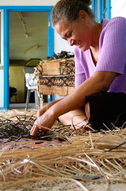 Mele Vaikeli cuts strips of prepared pandanus leaves to a uniform width.