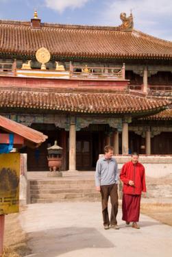 Peace Corps volunteer Sean Speer walks with a monk in a Mongolian monastery. Sean used his business skills to help the monks create a book about their monastery for tourists.