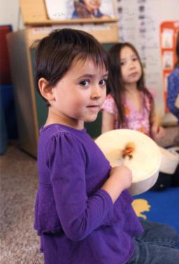 A child participates in a drumming activity in this Head Start classroom.