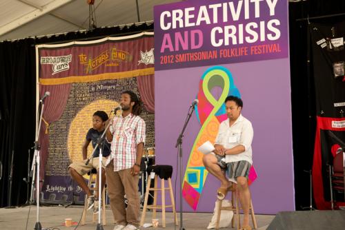 Mary Bowman and Regie Cabico listen as Dwayne Lawson-Brown performs at the 2012 Smithsonian Folklife Festival.