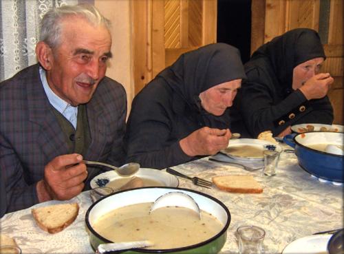At a funeral gathering in Kalotaszeg, elders feast on a traditional sour soup.