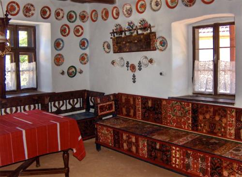 This traditional Kalotaszeg room features painted furniture, homespun textiles, and hand-painted ceramic plates used as wall decoration.