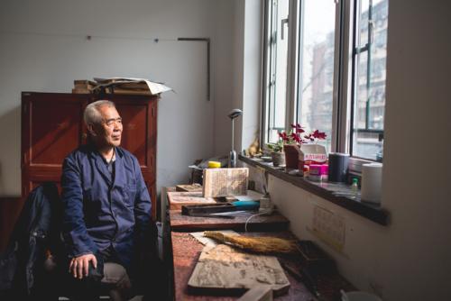 Wang Wenda takes a break from carving a woodblock.