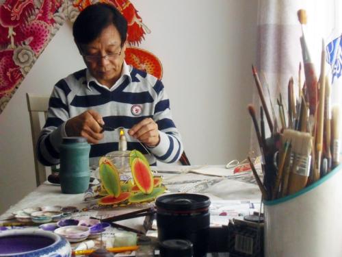Ha Yiqi works on shaping the frame of a miniature kite, Beijing, 2014.