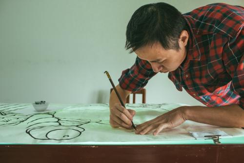Smithsonian Folklife Festival participant Gao Yan outlines a picture on rice paper.