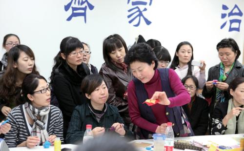 Jin Yuanshan leads a hands-on patchwork activity during an exhibition of her work.