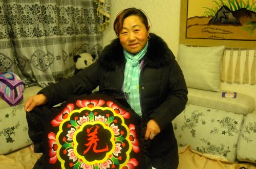 Li Xingxiu with an embroidered piece.