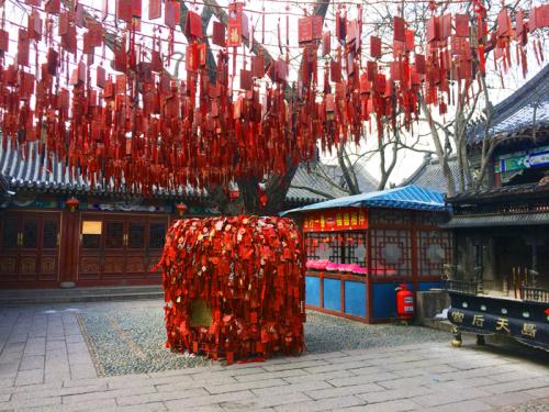 People express their hopes and wishes by tying blessing bags to and around trees at the Tianhou Palace in Qingdao, Shandong Province, 2014.