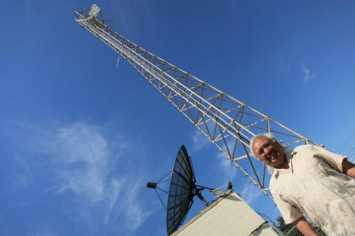 Radio Bilingüe co-founder Hugo Morales stands in front of their broadcast tower in Fresno.