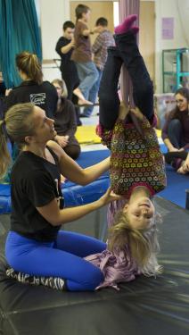 Youth program director Erin Lovett Sherman assists a young artist on the silks.