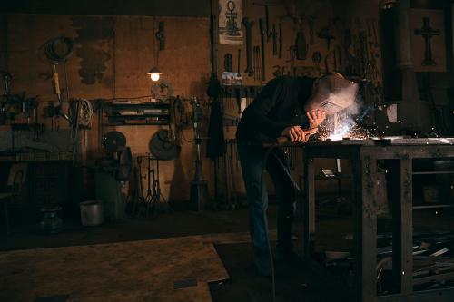 Papoyan works on a piece, covering his face with a welding mask.