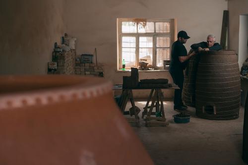 Gharibyan and his son work on a large tonir.