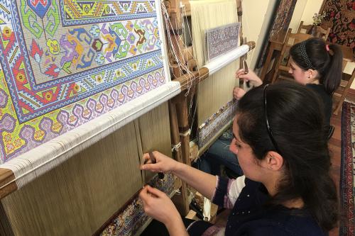 Students work on silk carpet designs at Silk Road Hotel in Yerevan.