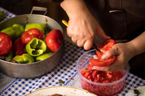 Preparation of summer tolma, a twist on the traditional grape leaf version that puts the filling into seasonal summer vegetables.
