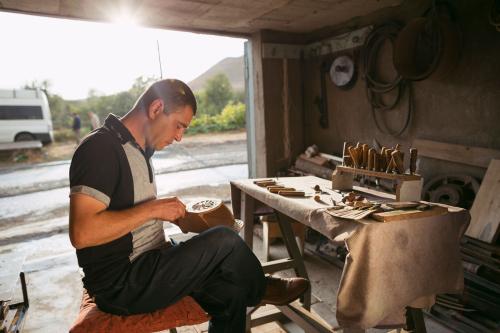 Armen Ohanyan works on carving detail for a spoon box. 