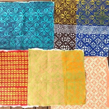 Six sheets of colorful printed barkcloth.