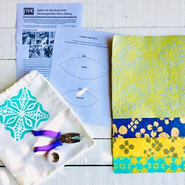 Four pieces of patterened square paper, a small cloth bag with stamped design, hole-puncher, spool of string, and two sheets of paper with craft instructions.