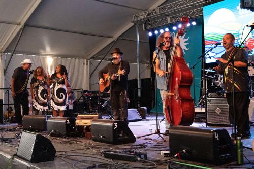 Two bands perform together on stage.