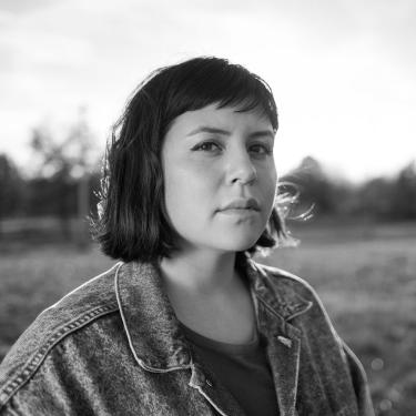 Kalyn Fay, in black and white, in denim jacket outdoors.