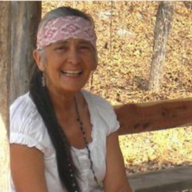 A smiling woman in a headwrap.