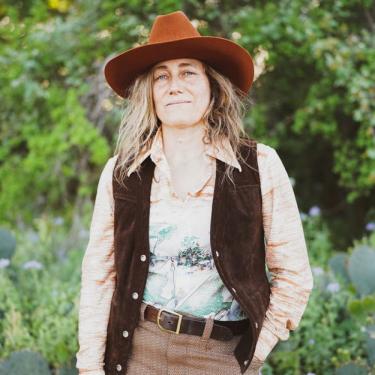 Melissa Carper in brown cowboy hat and vest.