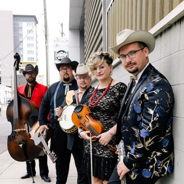 Five bandmembers holding their string instruments.