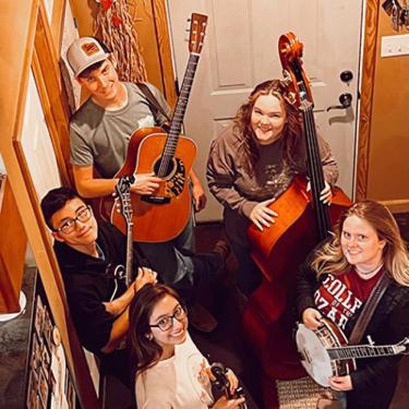 Five-piece string band holding their instruments.