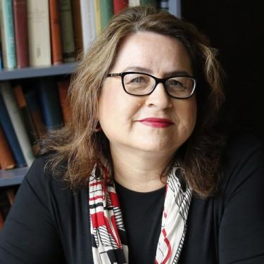 A woman wearing glasses and a red, black, and tan scarf.