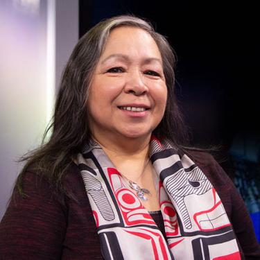 A woman wearing a black, red, and tan scarf.