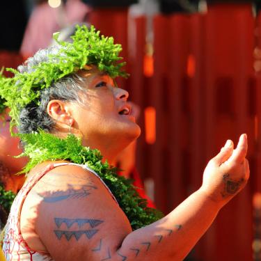 A woman wearing a foliage lei and crown.