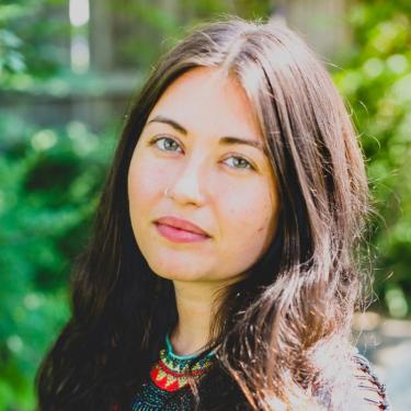 A woman with a beaded top on a green background.