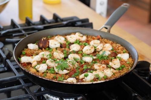 Shrimp, Chorizo, and Chicken Paella on a stovetop.