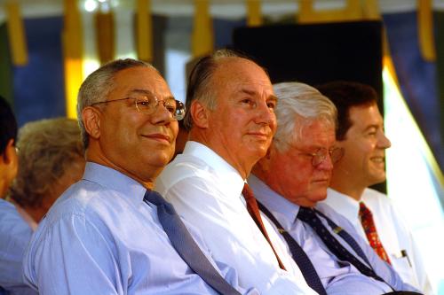 Four men in dress shirts and ties seated side by side.