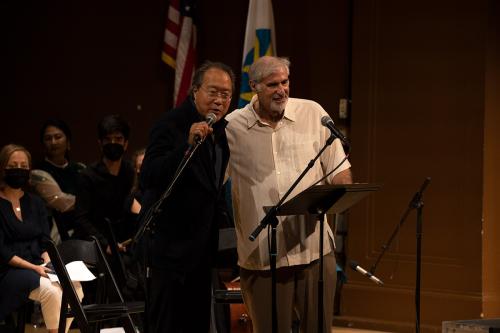 Two men standing on stage, arms around each other.