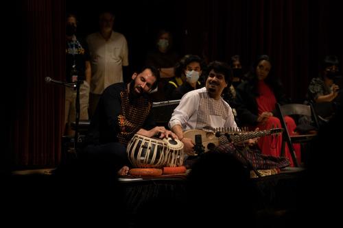Two performers seated, playing on stage.