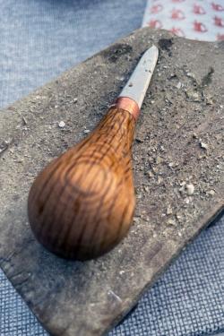Shucking knife with a bulbous wooden handle.