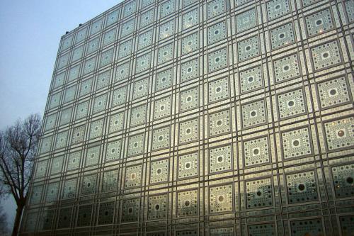 Building facade of reflective tiles with geometric pattern.